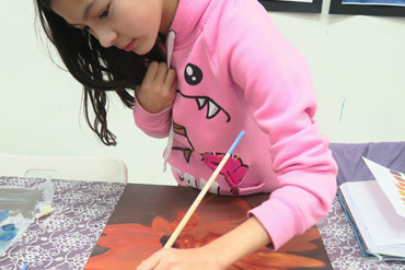 Child painting at camp